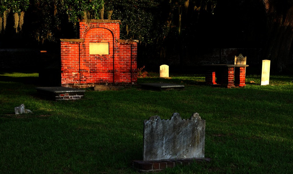 photo shows a few headstones in colonial park cemetery lit by the sunset