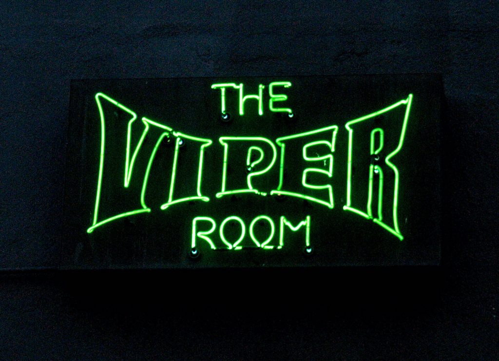 photo shows a green neon sign that says the viper room