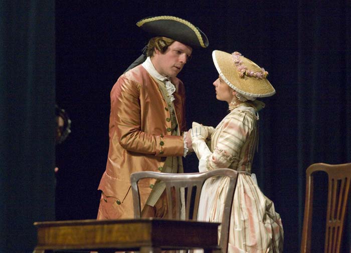 photo shows two people dressed in period clothing on a stage